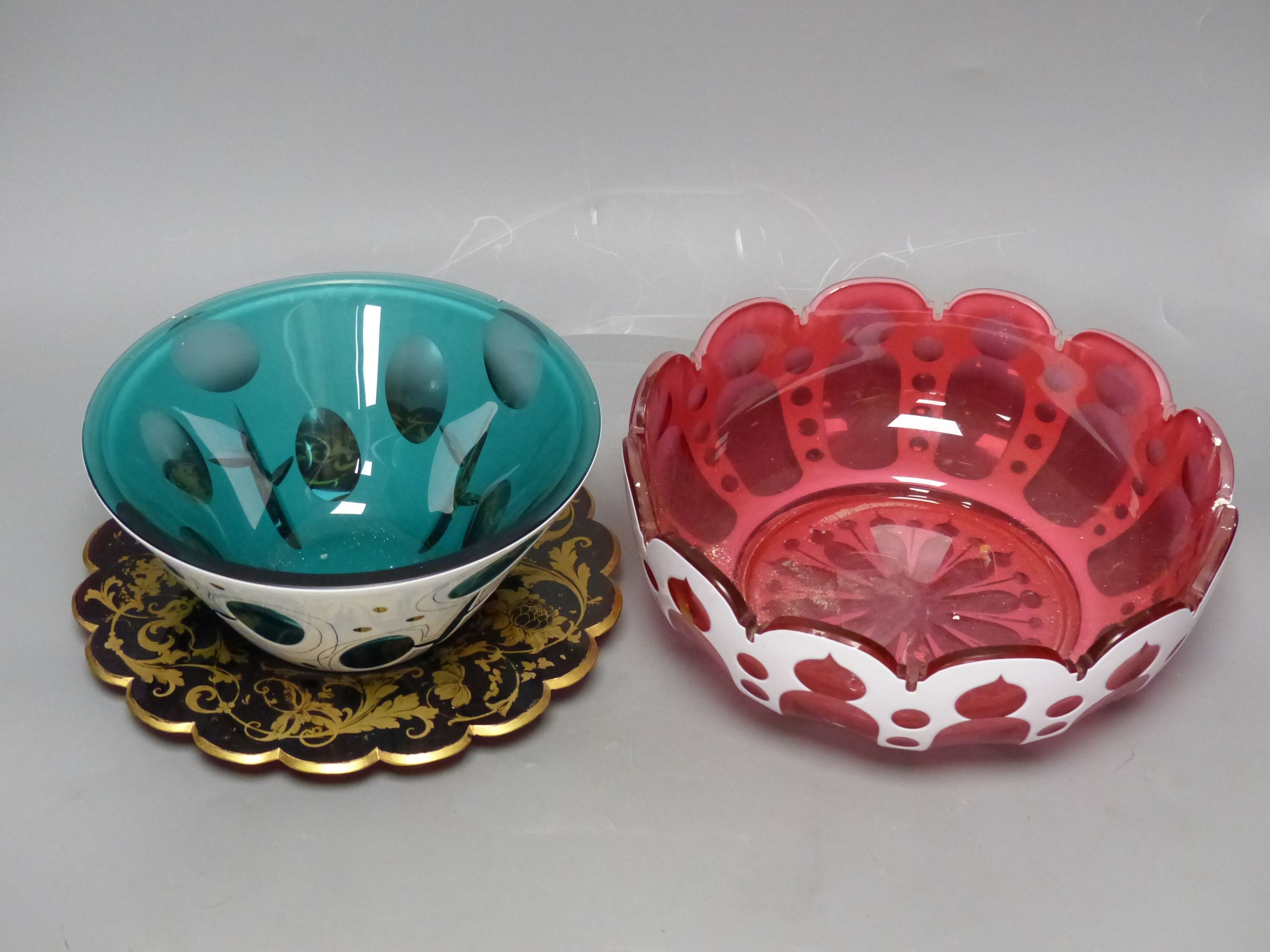A Bohemian cranberry and white overlay glass circular bowl, a similar conical turquoise bowl and a gilded ruby glass dish